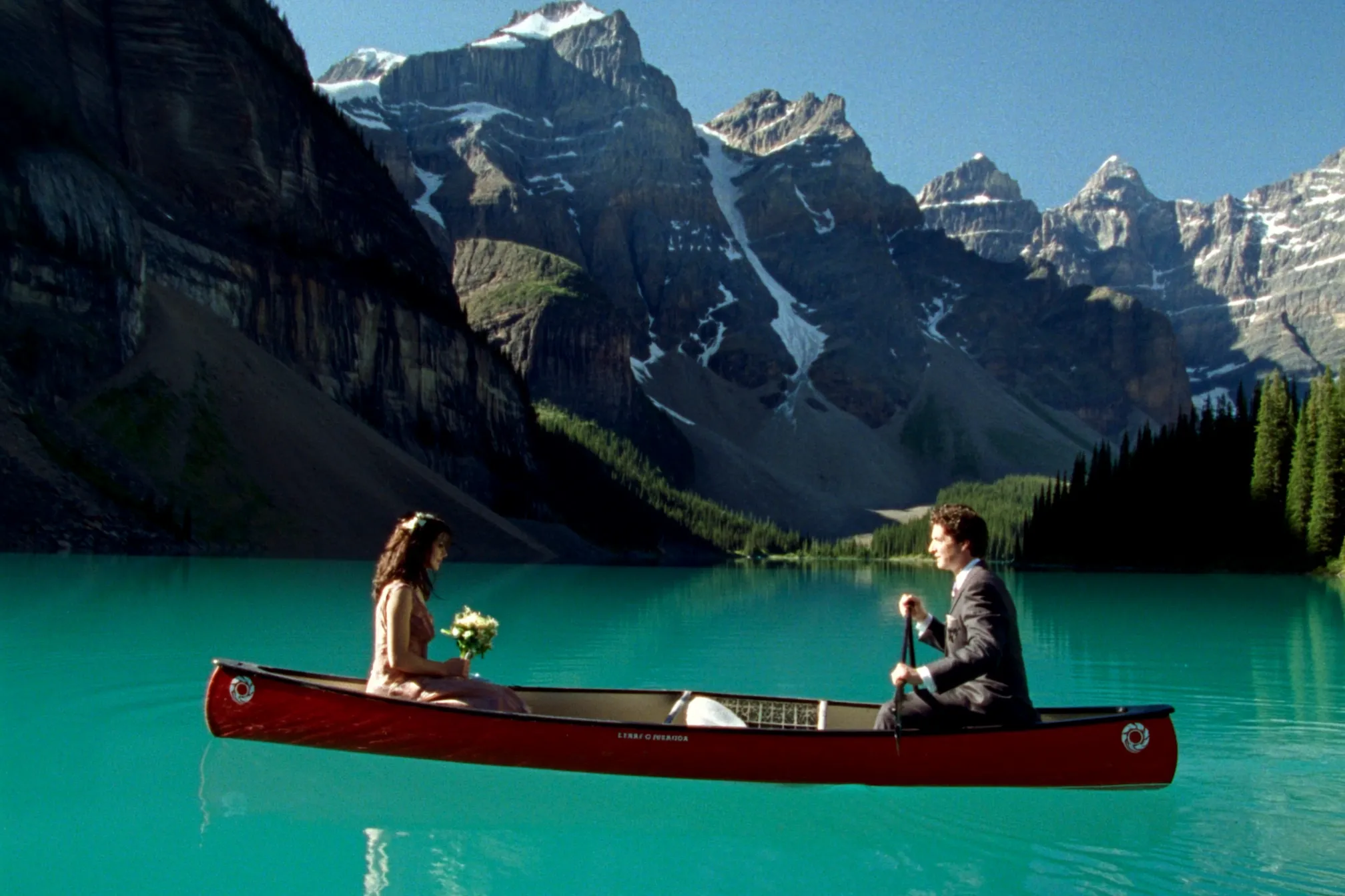 A couple in a canoe on the turquoise water of a Banff lake