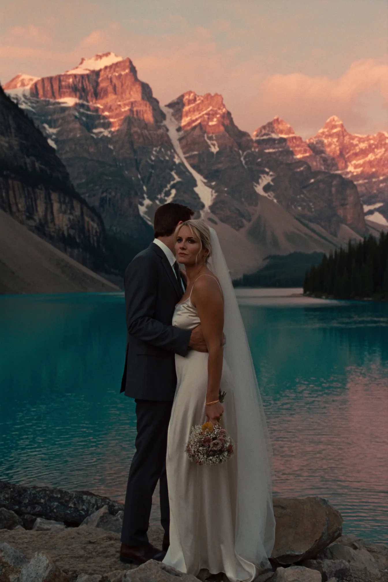 A couple at sunrise on the shore of Moraine Lake in Banff