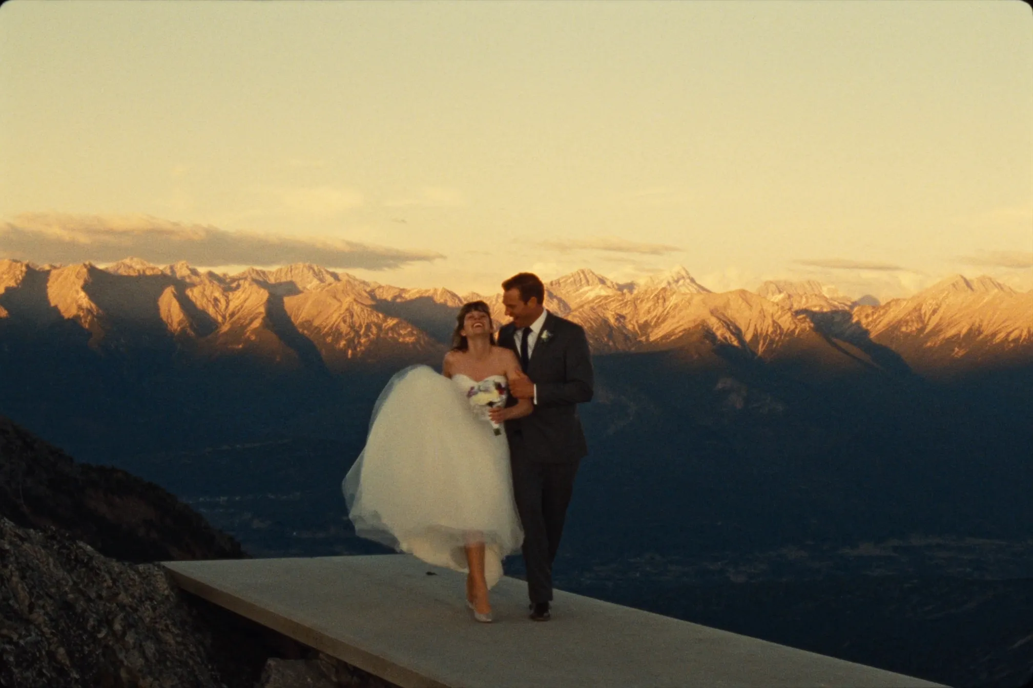 A couple on the Sulphur Mountain summit boardwalk at golden hour