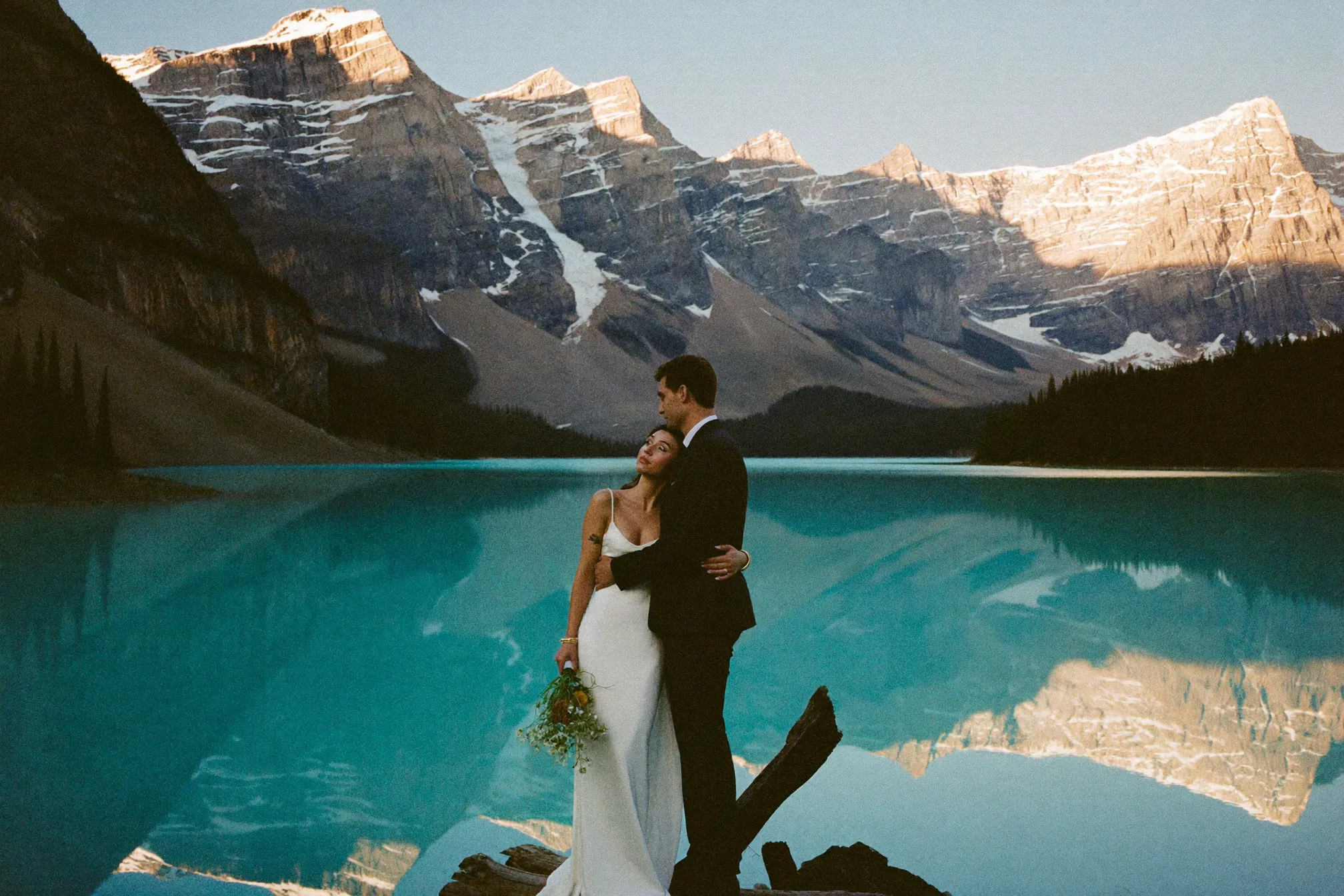 A couple at dawn on the shore of Lake Louise before the crowds