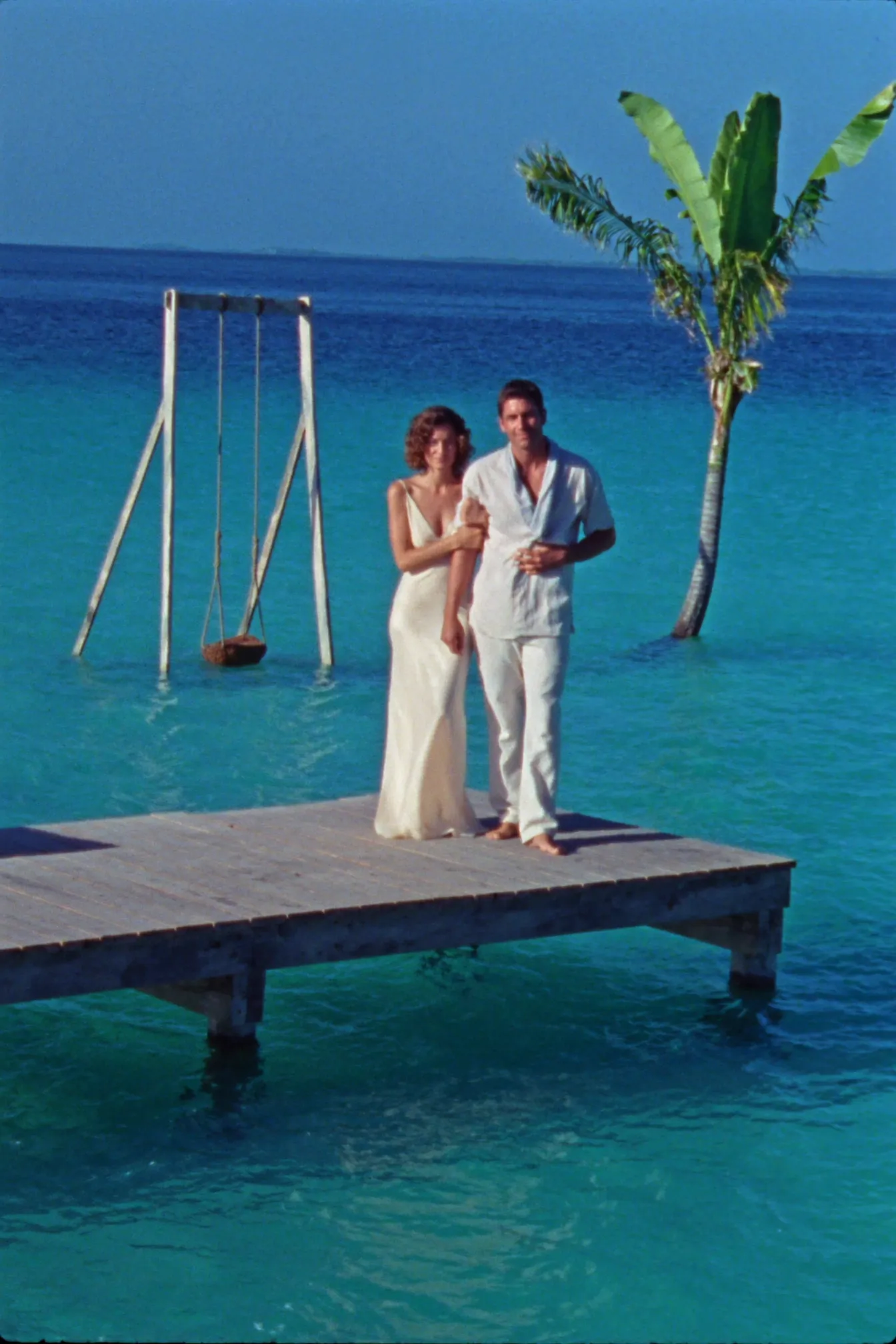 A couple eloping on a dock over the turquoise Lagoon of Seven Colors in Bacalar