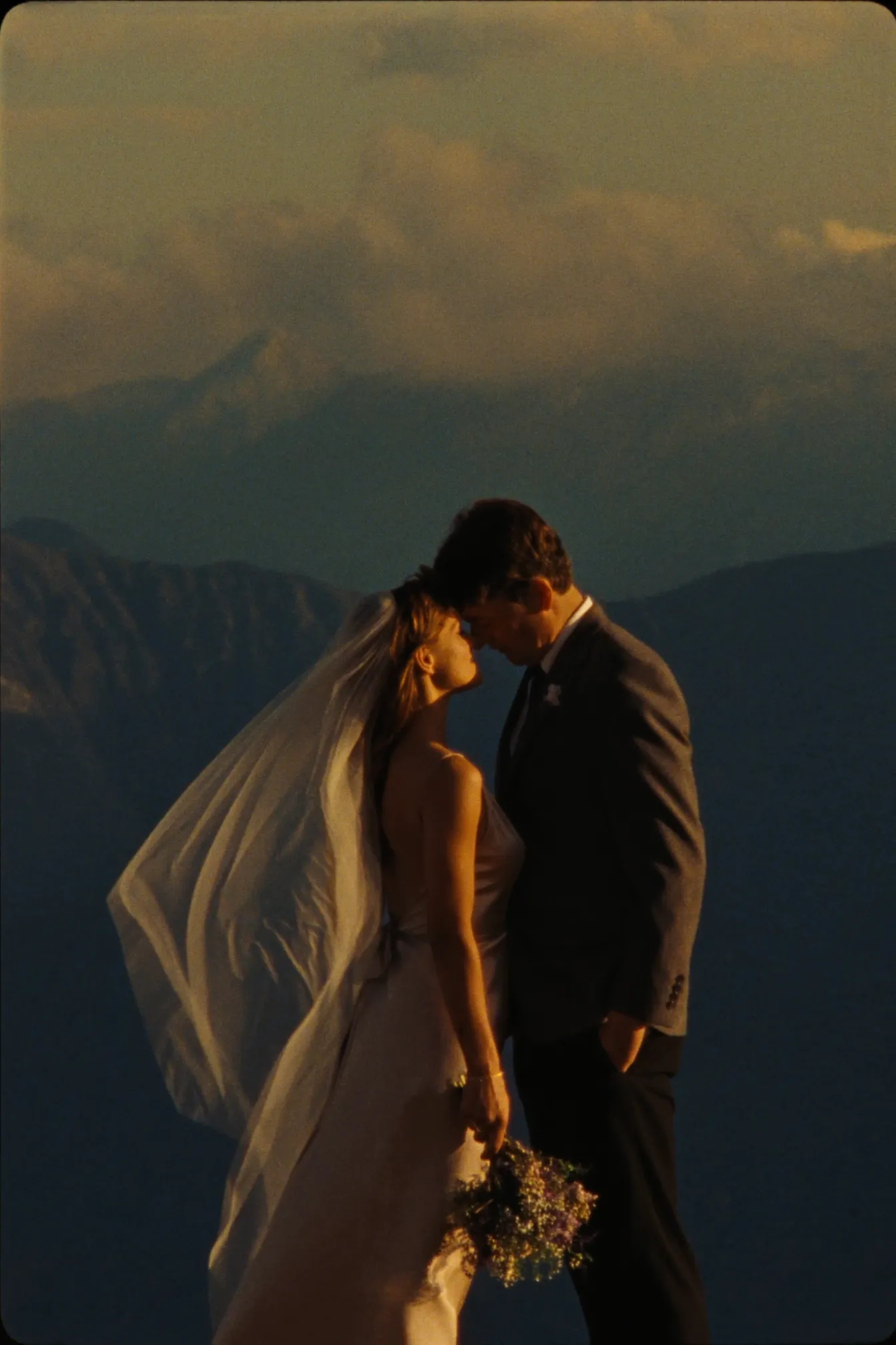 A couple on a Columbia Mountains ridge above Revelstoke at golden hour