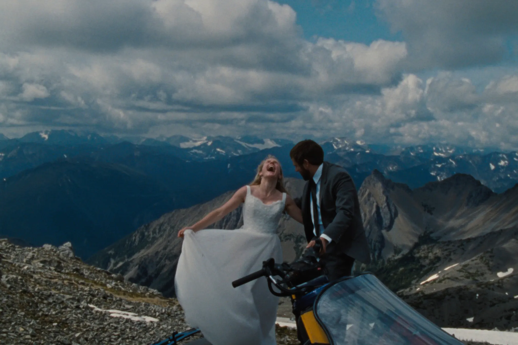 A couple beside a snowcat on a high remote ridge in the Columbia Mountains