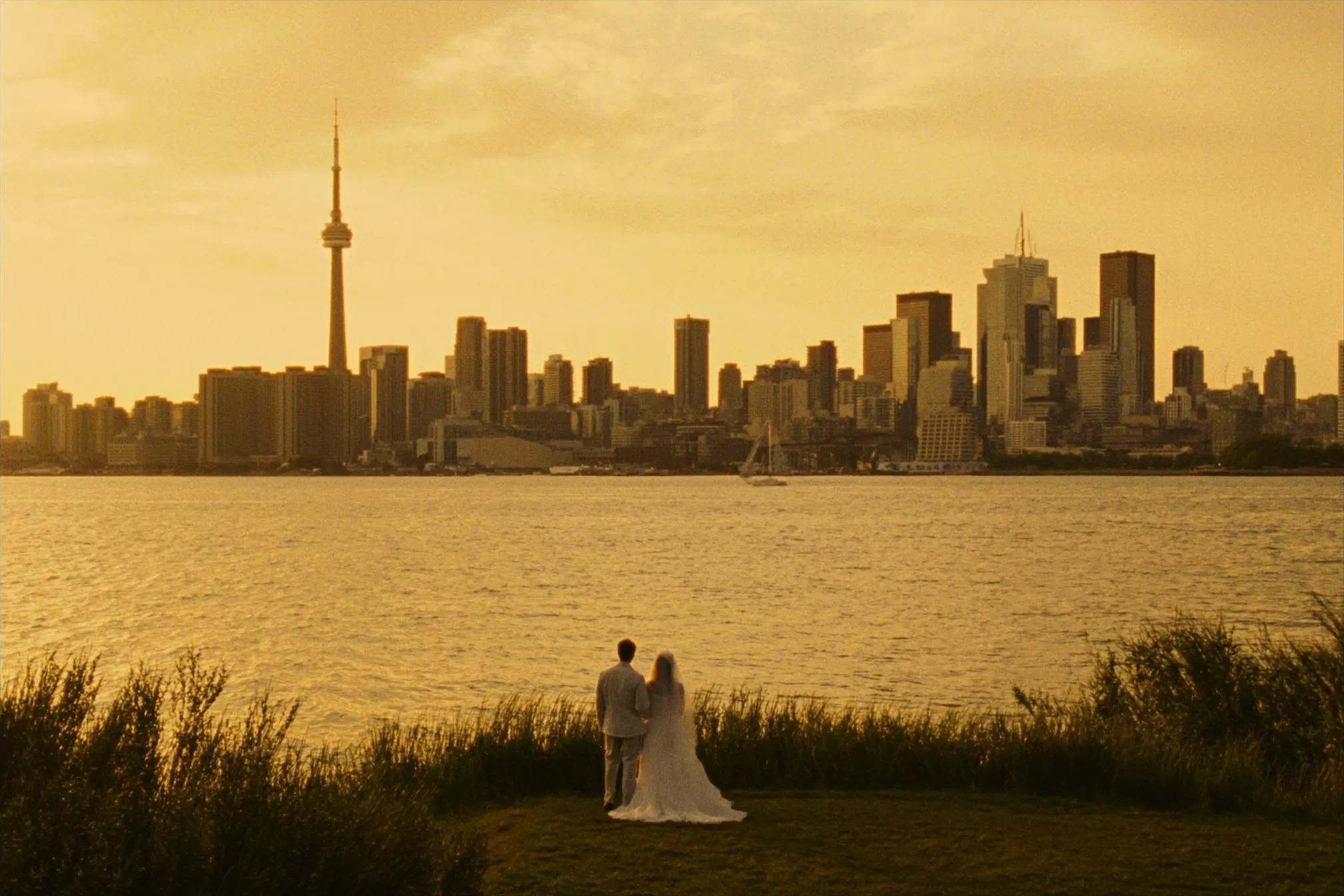 A couple eloping on the Toronto Islands with the skyline behind them