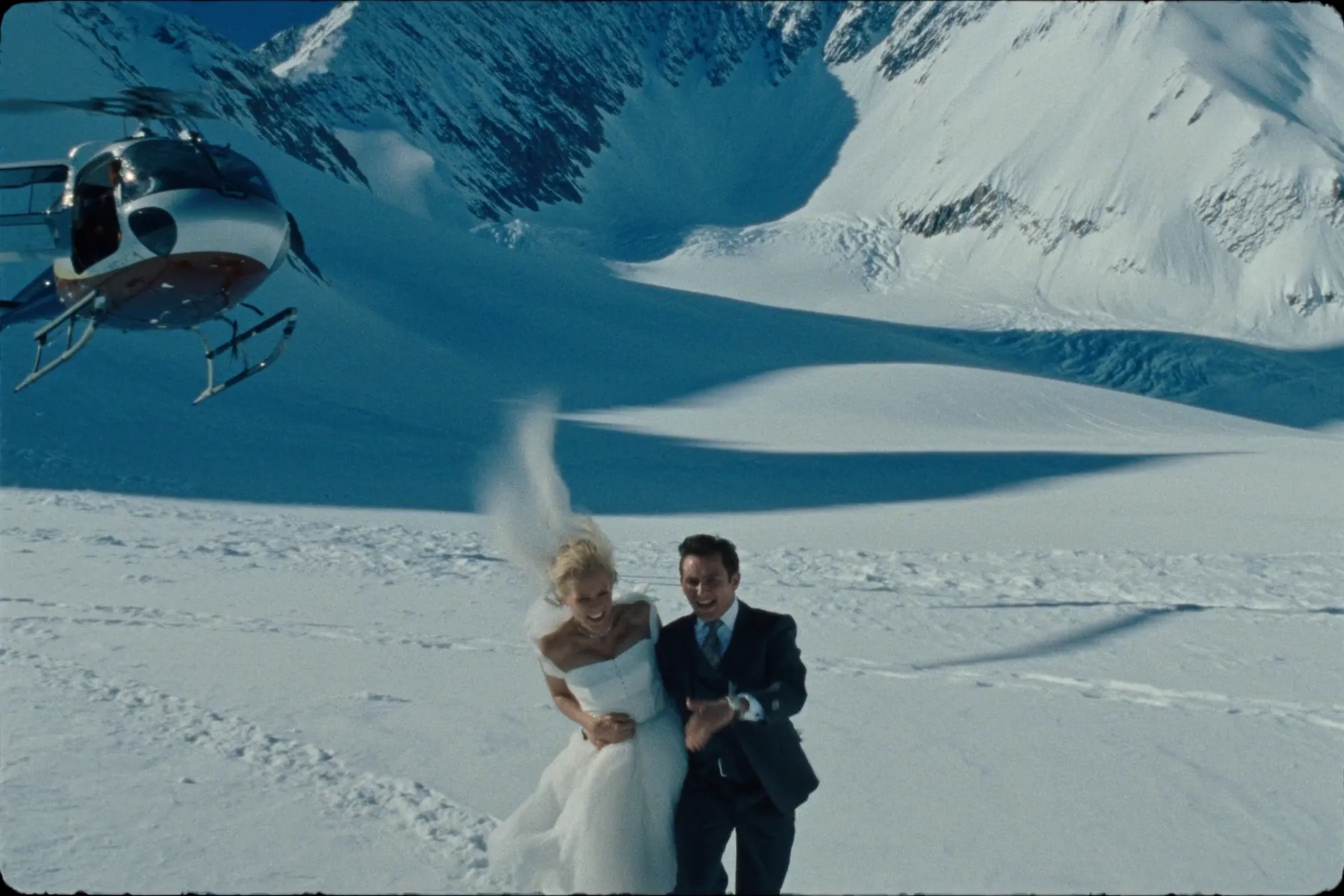 A couple on a glacier beside a helicopter near Whistler