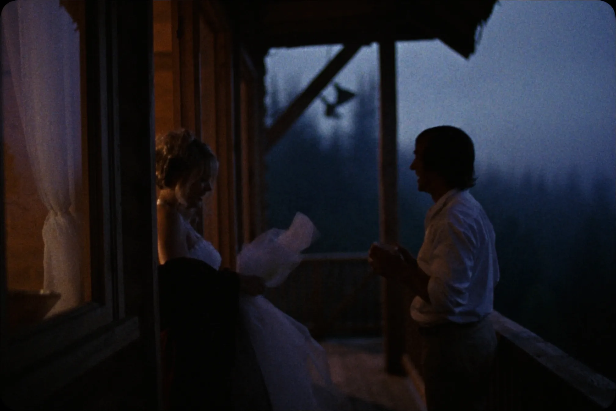 A couple meeting on a cabin porch at first light in Whistler